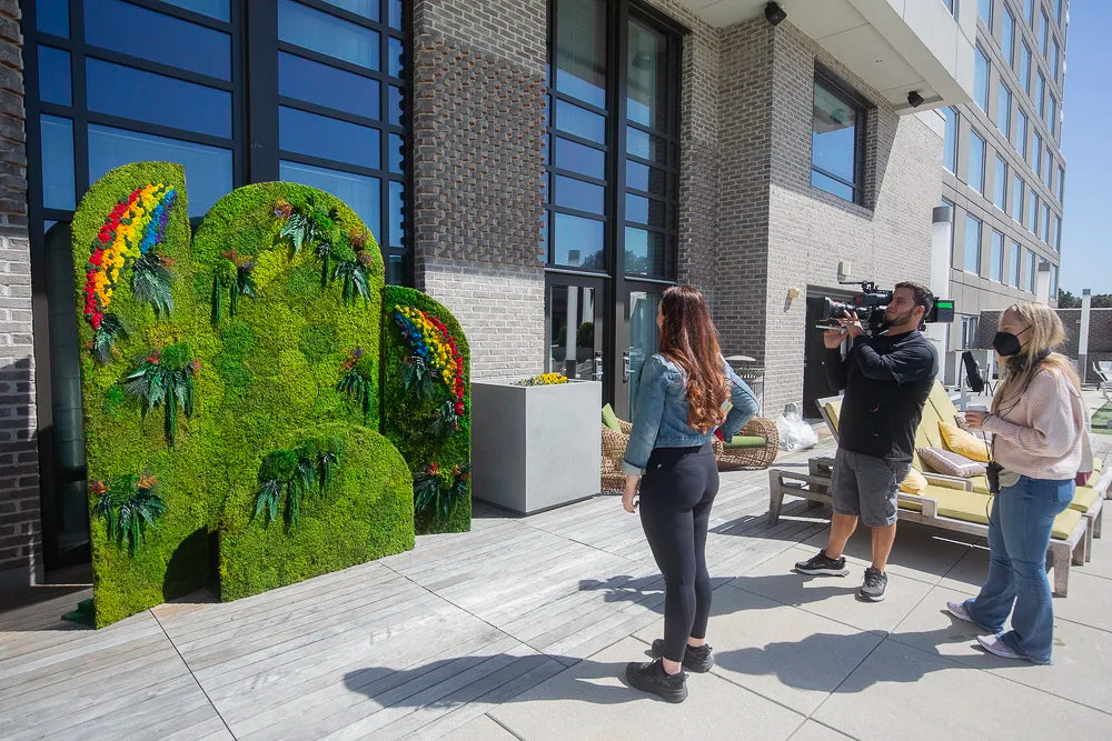 Camera crew filming Bravo TV's Family Karma in front of the rainbow moss step and repeat outdoors