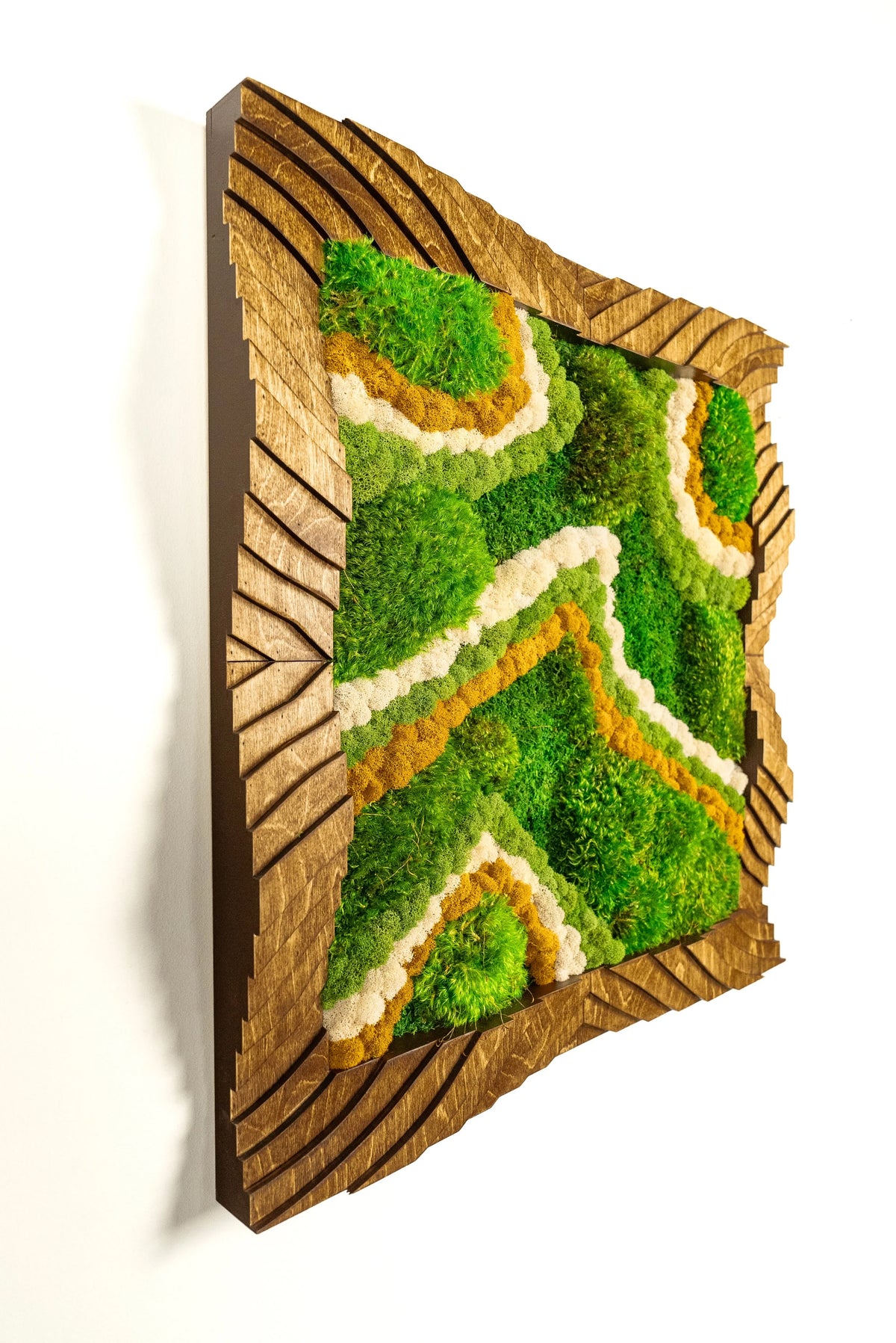 Detail of a Mel Sage topographic frame with moss following the carved wave contours