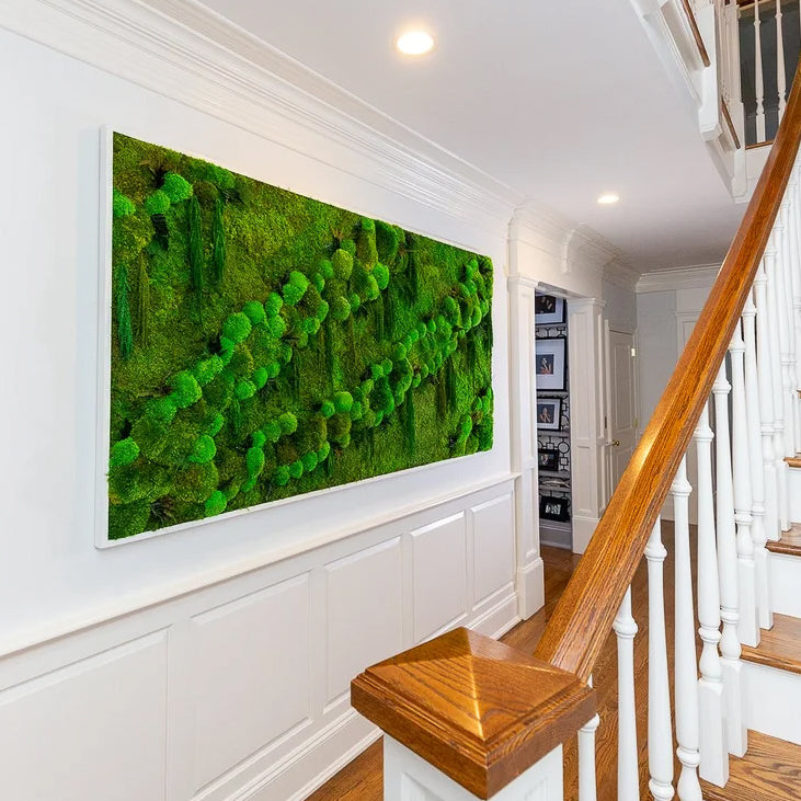 Long white framed moss panel with deep mounded texture above wainscoting in an entry hall by the stairs