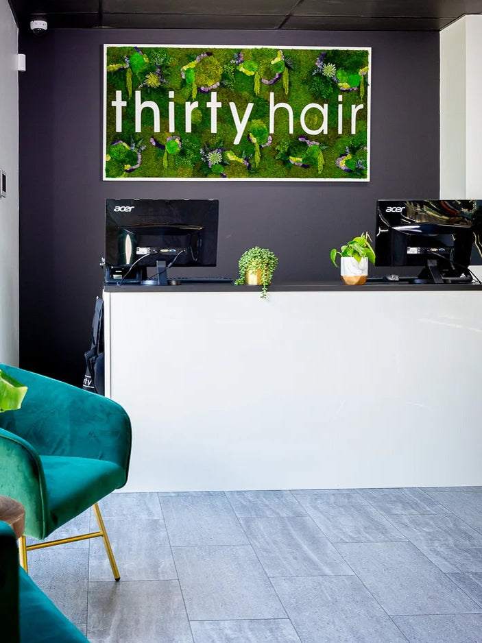 Moss sign reading thirty hair above the reception desk of a salon